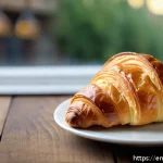 고급 제과 제품 추천 - A close-up, high-resolution image of an artisanal croissant on a rustic wooden table, showcasing its...